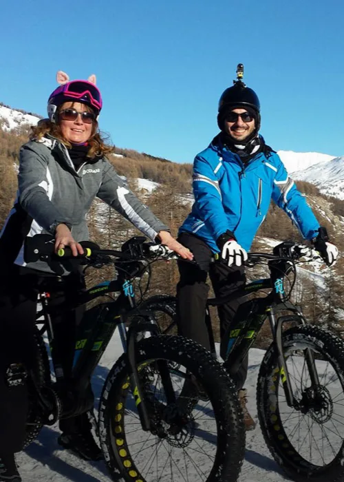 Escursionisti in e-bike con il paesaggio alpino sullo sfondo